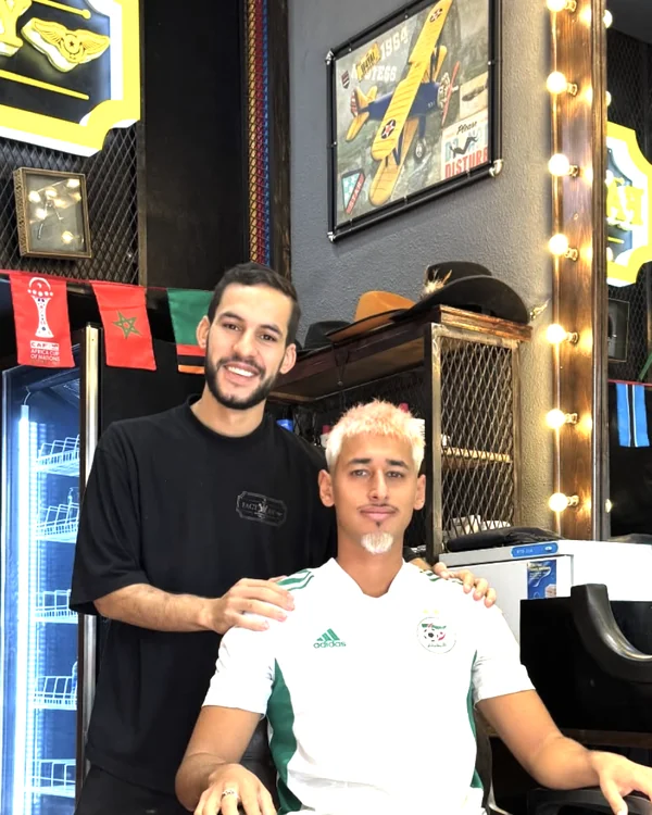 Barbier et client dans le salon décoré de drapeaux